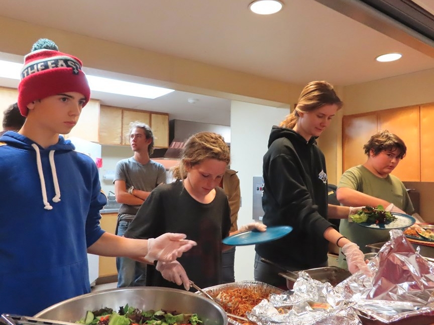 photo of four youth serving food