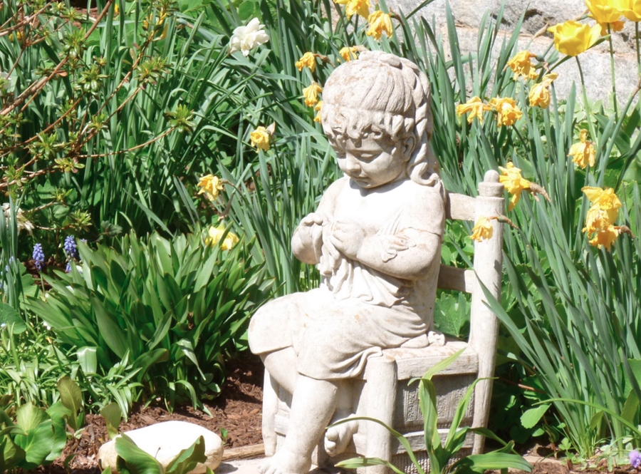 photo of a statue of a young child in the garden