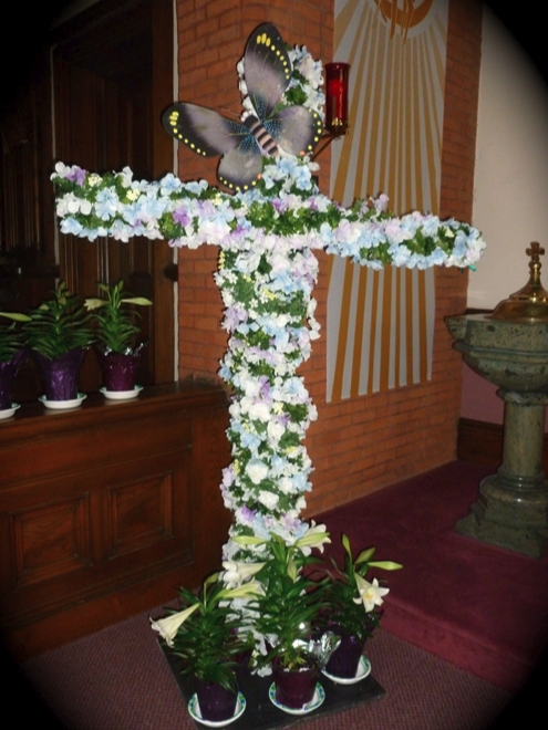 Photo of a cross covered with Easter Lillies